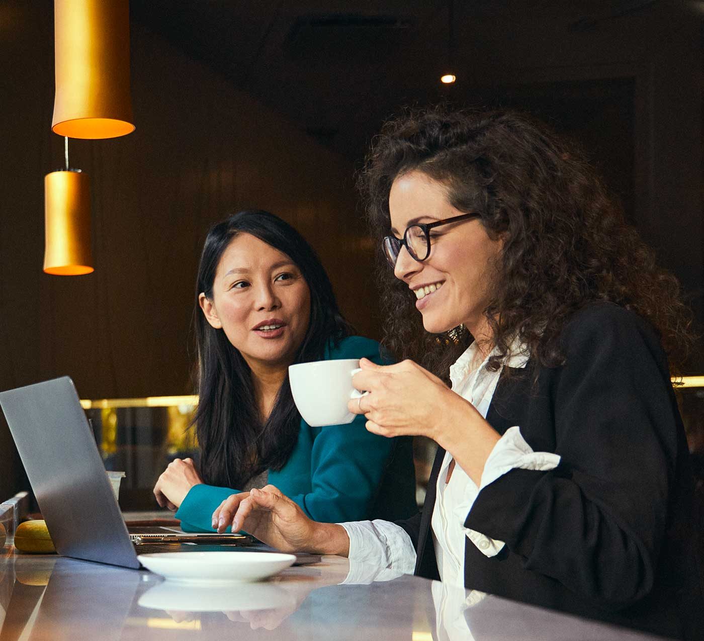 Två kvinnor dricker kaffe och samtalar